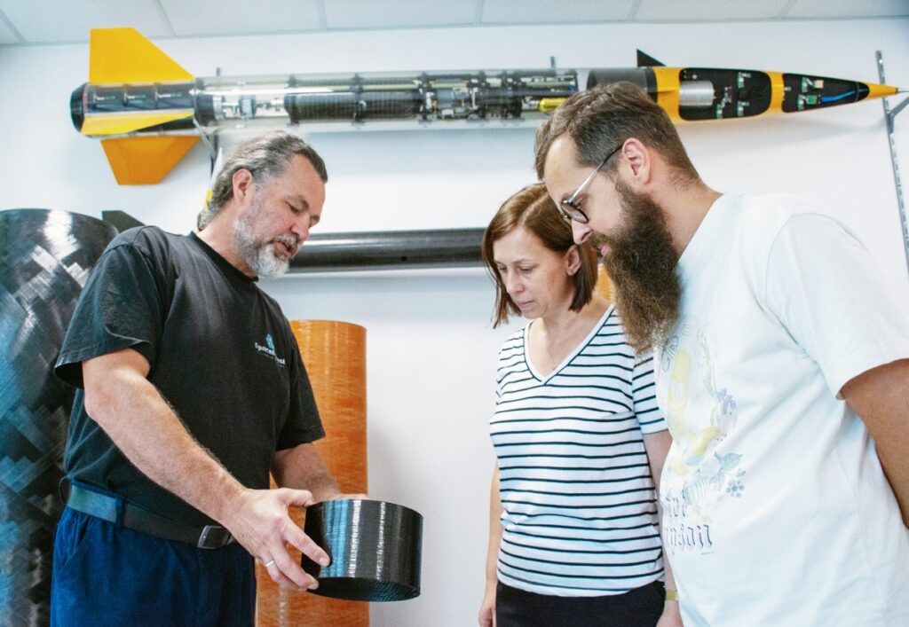 AGH researchers and SpaceForest engineers discussing a hypersonic rocket body made from carbon fiber fabric.