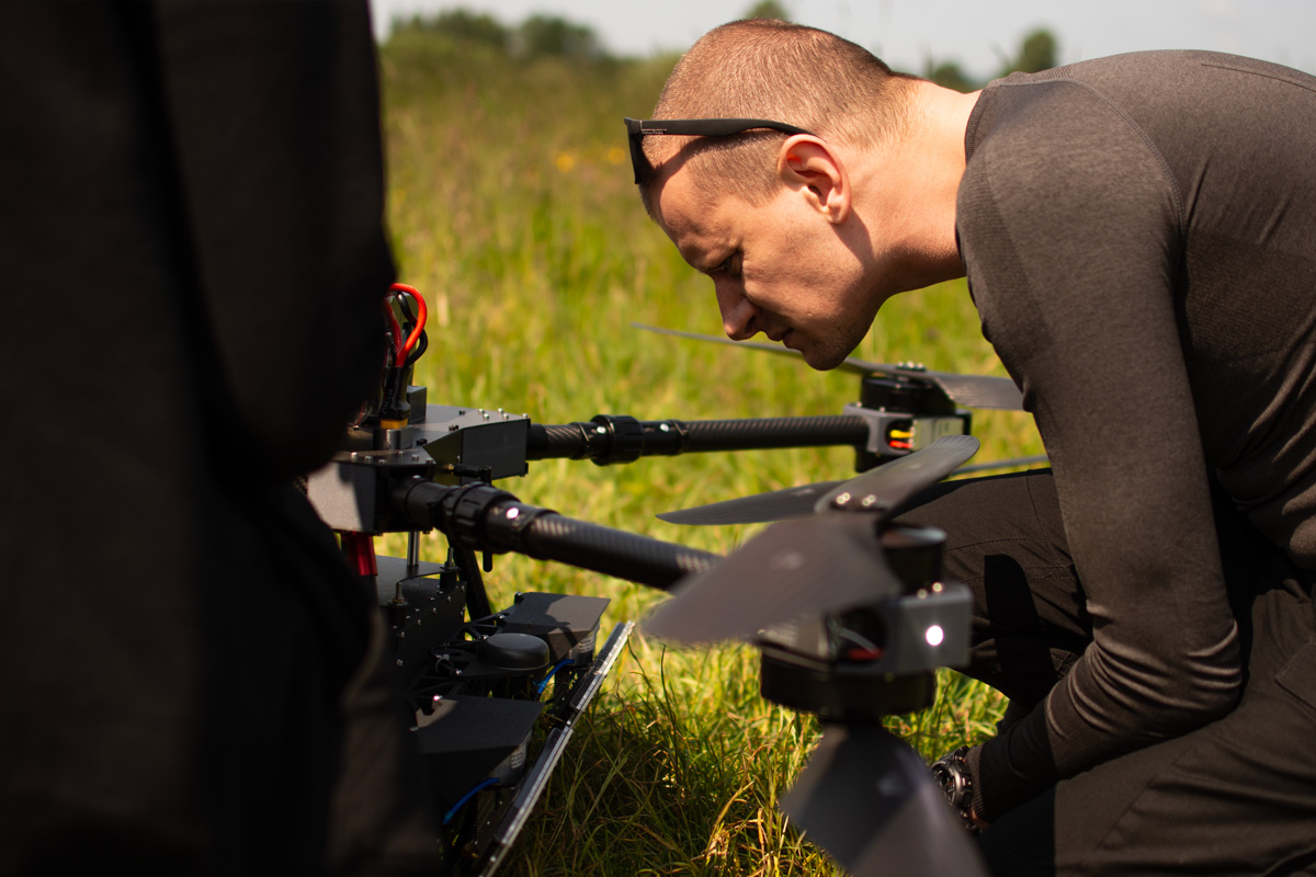 An operator meticulously checks the HUSSAR SAR radar system mounted on a drone before takeoff.